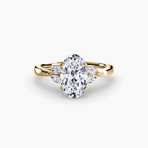 Gold ring with a large diamond and smaller diamonds on the sides against a white background